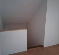 Schodiště v rodinném domě s podlahou s dřevěným dekorem.