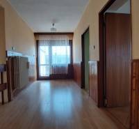 Chodba v rodinném domě s podlahou s dřevěným dekorem a obloženími ze dřeva.