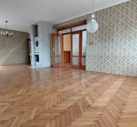 Prostorný pokoj s podlahou s dřevěným dekorem a vzorovanými tapetami v rodinném domě.