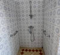 Sprchový kout s keramickými obklady v rodinném domě.