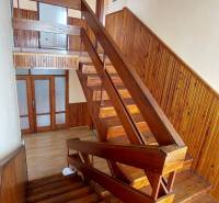 Schodiště s dřevěným obložením a dekorem v rodinném domě.