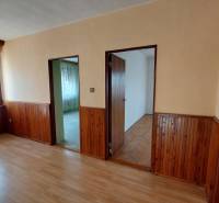 Pokoj v rodinném domě s podlahou s dřevěným dekorem a dřevěným obkladem stěn.