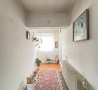 Chodba v rodinném domě s kobercem a podlahou s dřevěným dekorem.