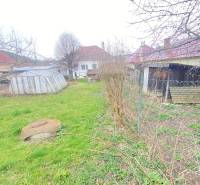 Zahrada u rodinného domu na Turej Lúce v Myjavě s trávníkem a přístřešky.