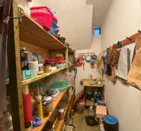 Úložný prostor v rodinném domě s policemi a různými kuchyňskými předměty.