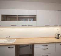 Kuchyňská linka v 2-pokojovém bytě s dřevěným dekorem pracovní desky.