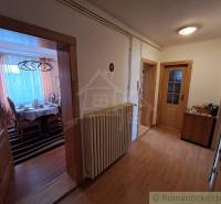 Chodba s podlahou s dřevěným dekorem v rodinném domě, útulné uspořádání nábytku.