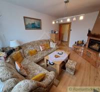 Obývací pokoj v rodinném domě s vyšívanou pohovkou, výklenková vývařovna, útulný interiér.