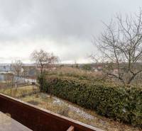 Výhled z 5 a více pokojového bytu ve Staré Lesné na zahradu a okolní domy.