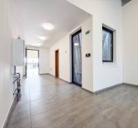 Interiér obchodního prostoru s dlážděnou podlahou a prosklenými dveřmi.