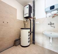 Interiér obchodních prostor s vytápěcím systémem, umyvadlem a podlahou s dřevěným dekorem.