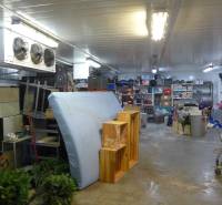 Sklady a haly s různým inventářem a úložnými regály.