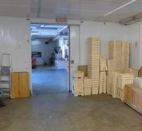 Interiér skladu s dřevěnými přepravkami a žebříkem, vhodný pro sklady a haly.