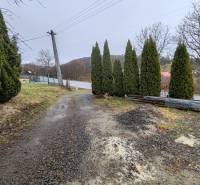 Cesta a stromy vedle rodinného domu na Hlavní ulici v Piskorovcích.