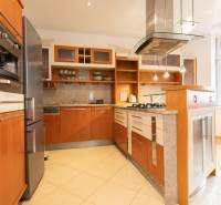 Kuchyně ve 4-pokojovém bytě s dřevěným dekorem a spotřebiči z nerezové oceli.