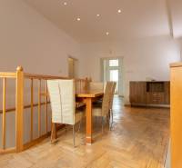 Jídelní kout ve 4-pokojovém bytě s podlahou s dřevěným dekorem a jídelním stolem.