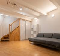 Obývací pokoj s pohovkou a schodištěm, podlaha s dřevěným dekorem, 4pokojový byt.