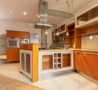 Kuchyně ve 4-pokojovém bytě s ostrůvkem a podlahou s dřevěným dekorem.