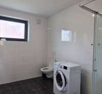 Koupelna se sprchovým koutem, umyvadlem a pračkou ve 3-pokojovém bytě.