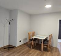 Jídelní kout se stolem a židlemi, podlaha s dřevěným dekorem v 3-pokojovém bytě.