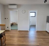 Kuchyně v 3pokojovém bytě s podlahou s dřevěným dekorem a jídelním stolem.