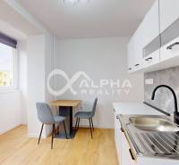 Kuchyně v 1-pokojovém bytě s podlahou s dřevěným dekorem a jídelním stolem.