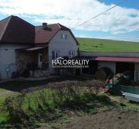 Rodinný dům v Rimavských Janovcích, s červenou střechou a rozlehlou zahradou.