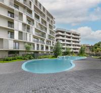 Součástí rezidenční oblasti na Poliankách v Bratislavě-Dúbravce je bazén a moderní architektura bytovky.