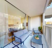 Balkon s posezením, výhled na okolní budovy, skleněné dveře do garsonky.