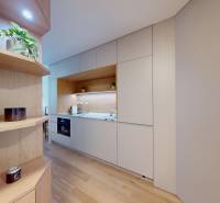 Kuchyně v 1-pokojovém bytě s bílými skříňkami a dřevěným dekorem.