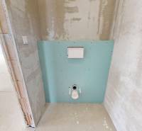 Toaleta v rodinném domě s připravenou instalací na obklady a zařízení.
