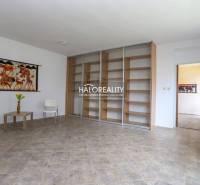 Obývací pokoj s podlahou s dřevěným dekorem, nástěnnou tapisérií a policovým systémem.