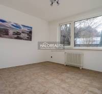 Prostorný pokoj s oknem a radiátorem v rodinném domě.