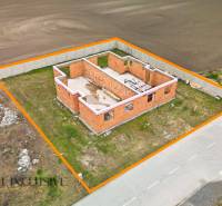 Rozestavěný rodinný dům ve Velkých Dvorníkách, ohraničený oranžovou čarou, situovaný u cesty.