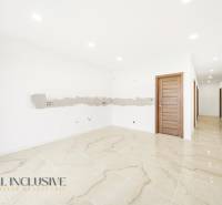 Interiér rodinného domu s lesklou dlažbou a dřevěnými dveřmi.