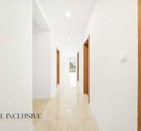 Interiér rodinného domu se světlými stěnami a gresovou podlahou.