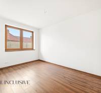 Bílá stěna a podlaha s dřevěným dekorem v místnosti rodinného domu.