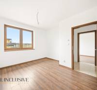 Interiér s podlahou s dřevěným dekorem, velkým oknem a dveřmi v rodinném domě.