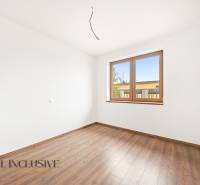 Pokoj v rodinném domě s podlahou s dřevěným dekorem a velkým oknem.