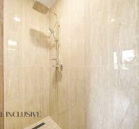 Sprchový kout v rodinném domě s mramorovým obkladem.