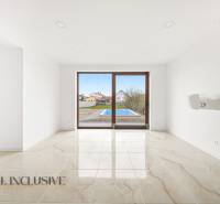 Interiér rodinného domu s velkými okny a výhledem na dvůr s bazénem.