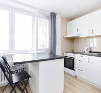 Kuchyně v 2-pokojovém bytě s pultem a podlahou s dřevěným dekorem.