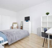 Ložnice v 2-pokojovém bytě s bílým nábytkem a podlahou s dřevěným dekorem.