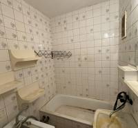 Koupelna v 2-pokojovém bytě s vanou, umyvadlem a dlaždičkami.