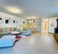 Obývací pokoj v rodinném domě s pohovkou, dekoracemi a podlahou s dřevěným dekorem.