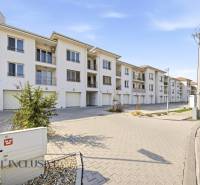 Komplex bílých budov a parkovacích míst v Dunajské Stredě, ideální pro 4pokojový byt.