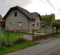 Rodinný dům na ulici Blatnica ve městě Blatnica s jednoduchou zahradou a kovovým plotem.