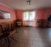 Gastro prostory s dlažbou, růžovými stěnami a stohovaným nábytkem.