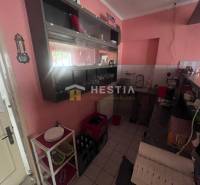 Kuchyňský kout v gastro prostorech s pultem, policemi a vybavením.