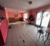 Kavárna s cihlovou stěnou a prázdnými židlemi, gastro prostory.